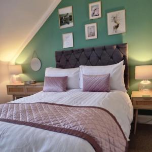 a bedroom with a large bed with green walls at Rose Villa in Oban