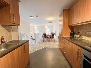 格拉斯哥的住宿－Duplex Apartment in Glasgow，一间带木制橱柜的厨房和一间用餐室