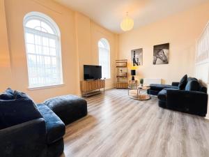 a living room with two couches and a tv at Duplex Apartment in Glasgow in Glasgow