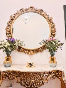 un miroir en or ornementé sur une table avec des fleurs dans l'établissement Puerta del Agua, à Uclés