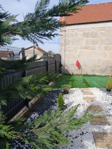 einen Hinterhof mit einem Zaun und einem Garten mit Pflanzen in der Unterkunft Casa com Piscina e Hidromassagem e Kids Zone in Nelas
