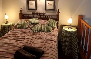 1 dormitorio con 1 cama con almohadas y 2 lámparas en El último rincón, dúplex con piscina climatizada en La Pinilla