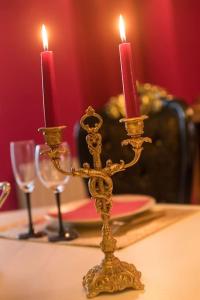 um castiçal de ouro com duas velas numa mesa em La Rose Médiévale Balnéo & Sauna em Domfront