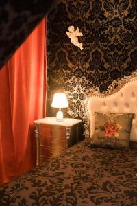 um quarto com uma cama e uma mesa com um candeeiro em La Rose Médiévale Balnéo & Sauna em Domfront