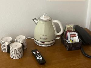 a tea kettle and a remote control on a table at Hotel Montecodeno in Varenna