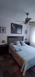 a bedroom with a large bed with a ceiling fan at Urbanización la barca in Oropesa del Mar