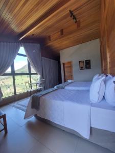 a bedroom with a large bed with a wooden ceiling at Villa di Madeira in Divisa