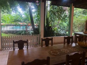 a dining room with chairs and a large window at Sítio charmoso in Jarinu