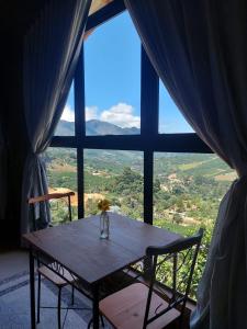 a table and chairs in front of a large window at Villa di Madeira in Divisa