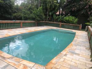 a swimming pool with blue water in a backyard at Sítio charmoso in Jarinu