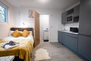 a small bedroom with a bed and a kitchen at Sleek and Stylish Studio: Old Trafford in Manchester