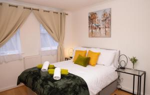 1 dormitorio con 1 cama con almohadas amarillas y verdes en Stunning 1-Bed Apartment close to Hotspur en Enfield