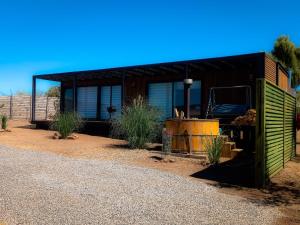 a green building with a truck in front of it at Cabaña con Tinaja -Litueche in Navidad