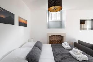 a white bedroom with a bed and a fireplace at Le Descartes emplacement idéal - Gare centre in Rennes