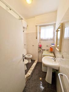 une salle de bain avec deux toilettes et un lavabo dans l'établissement Appartamento ALICE a Marina di Cecina by Zoom In Earth, à Marina di Cecina 13 autres photos