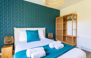 um quarto com uma cama com uma parede verde em Le Celadon - Joli T3 moderne - 2 chambres avec em Cancale