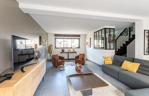 a living room with a couch and a table at Villa Ty Laouen- Maison moderne 3 chambres jardin in Dinard