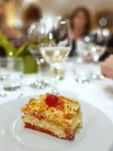 un morceau de gâteau sur une plaque blanche sur une table dans l'établissement Hotel Squarciarelli, à Grottaferrata