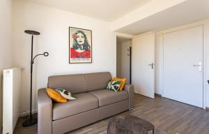 a living room with a couch and a lamp at La Rossa proche métro parking privé in Rennes