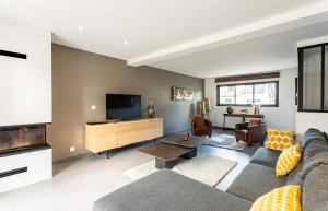 - un salon avec un canapé et une télévision dans l'établissement Villa Ty Laouen- Maison moderne 3 chambres jardin, à Dinard