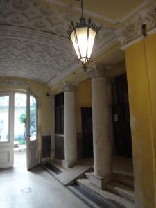 an empty room with a chandelier and columns at M Apartments - Downtown in Budapest