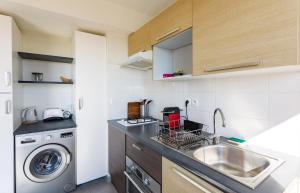 a kitchen with a sink and a washing machine at La Rossa proche métro parking privé in Rennes