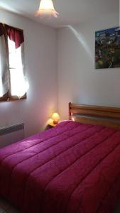 ein Schlafzimmer mit einem großen Bett mit einer lila Decke in der Unterkunft Résidence Eugenie - 2 Pièces pour 4 Personnes 964 in Guchen