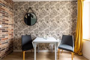 ein Esszimmer mit einem Tisch, 2 Stühlen und einem Spiegel in der Unterkunft La Brise- Joli T2 rénové - Vue Mer - 1 chambre in Cancale
