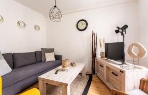 a living room with a couch and a tv at Le Gardelle - Jolie maison de ville (2 chambres) in Saint Malo