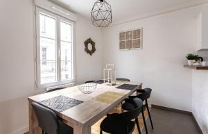 uma sala de jantar com uma mesa de madeira e cadeiras em Le Gardelle - Jolie maison de ville (2 chambres) em Saint Malo