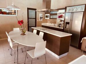 a kitchen with a white table and white chairs at Maison AdriAnna in Vedène