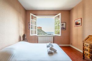 ein Schlafzimmer mit großem Bett und Fenster in der Unterkunft Les Aiguadines par Dodo à Cassis in Cassis
