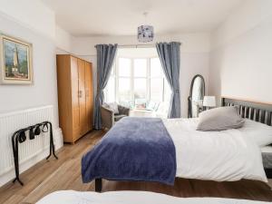 a bedroom with two beds and a large window at 46 The Promenade in Withernsea