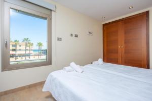 a bedroom with a bed and a window with the beach at Antonia in Can Picafort