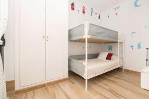 een kinderkamer met een stapelbed en witte kasten bij Loving Rota in Rota +17 foto's