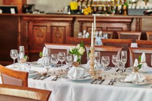 una mesa en un restaurante con mantel blanco y copas de vino en St Peter Vini, en Svätý Peter