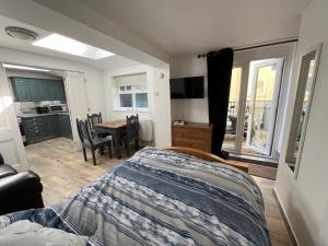 a bedroom with a bed and a dining room table at Seagull studio in Felixstowe