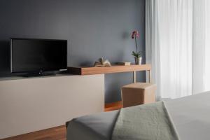 a living room with a flat screen tv on a table at The Regent Boutique Hotel & Spa PRE OPENING in San Marino