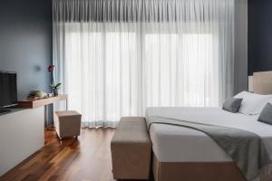 a bedroom with a bed and a large window at The Regent Boutique Hotel & Spa PRE OPENING in San Marino