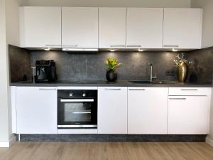 a kitchen with white cabinets and a sink at Neu & Schick: Küche inkl. Kaffee in Dresden