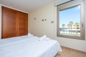 een slaapkamer met een bed en een raam met uitzicht op het strand bij Joan in Can Picafort