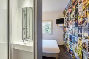 W łazience znajduje się umywalka i lustro. w obiekcie hotelF1 Chilly Mazarin les Champarts w mieście Chilly-Mazarin