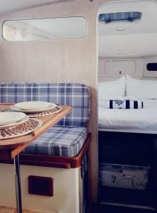 a room with a bed and a table with plates on it at Cosy and Homey Houseboat Castelldefels in Barcelona
