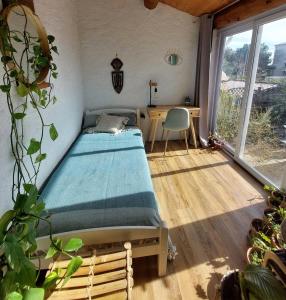 a bedroom with a bed and a desk and a window at Villa 80 m2 jardin terrasse 3 chambres Provence in Volx