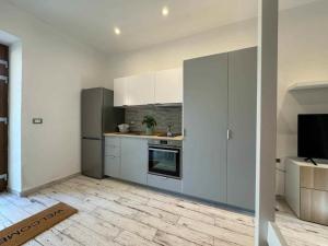 a kitchen with white cabinets and a television in it at Casa Bruno in Marciana