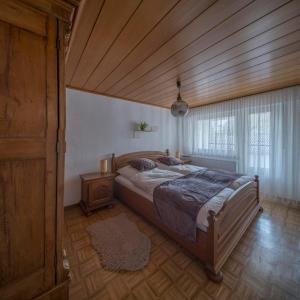 a bedroom with a large bed and a wooden ceiling at Das Schmitz Haus, Ferienhaus in Meckel