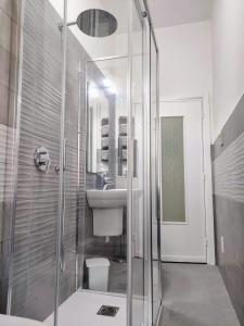 y baño con ducha acristalada y lavamanos. en La Dormidera, en Alghero
