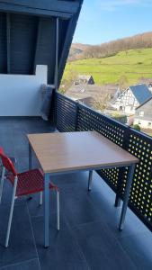 einen Holztisch und zwei Stühle auf dem Balkon in der Unterkunft Mony land in Netphen
