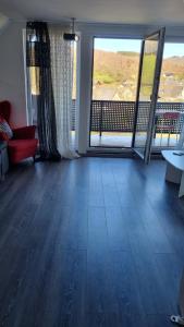 sala de estar con suelo de madera y ventanas grandes en Mony land en Netphen