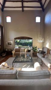 een woonkamer met banken en een glazen tafel bij Casa Cayé Solar del Plata in Vistalba